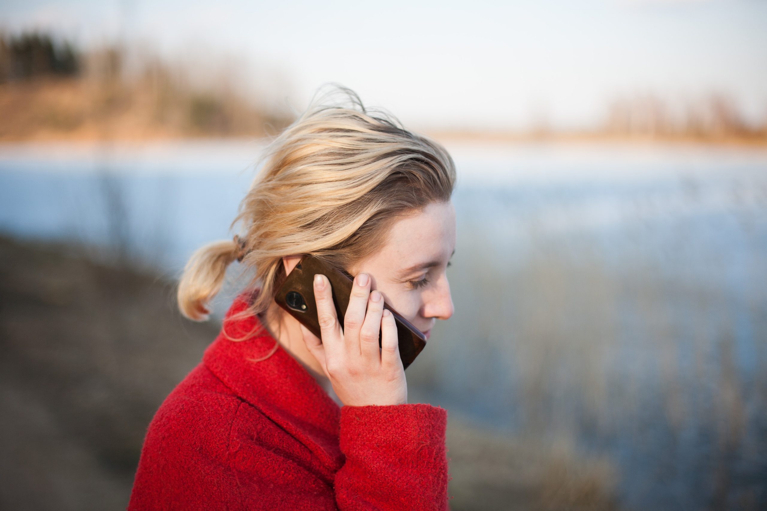 Woman outside holding a cell phone to her ear.
