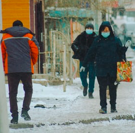 People walking on a snowy sidewalk.