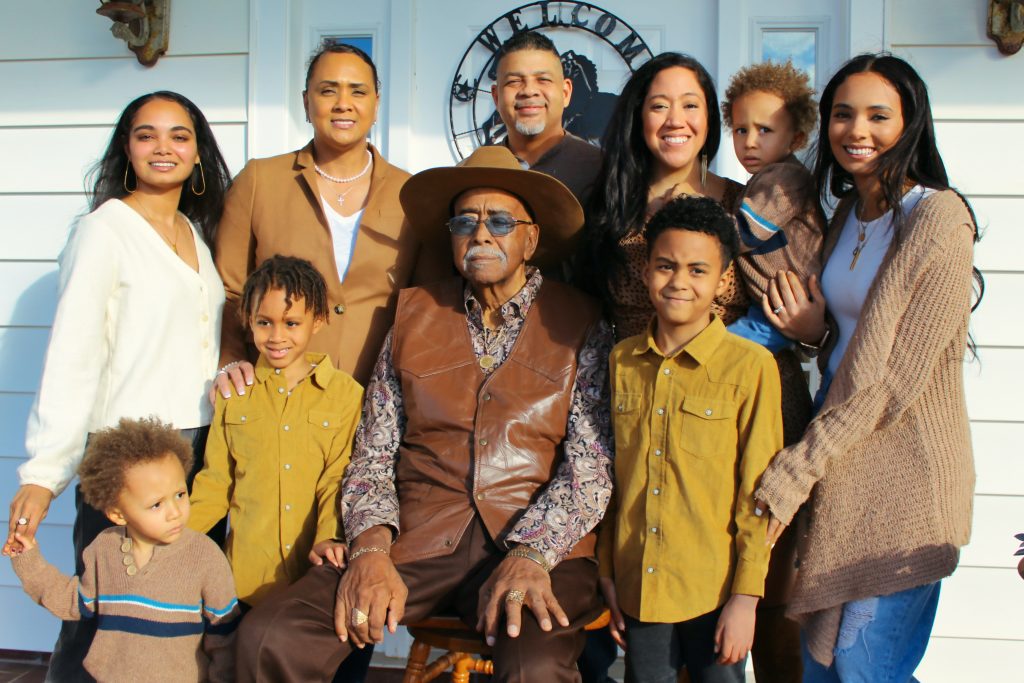 A Hispanic family posing in front of a white door